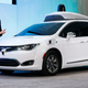 Waymo’s CEO John Krafcik standing before a Chrysler Pacifica self-driving test car. Photo Credit: AP